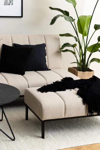 Podnóżek tapicerowany Caix beżowy Actona do salonu i sypialni, nowoczesny prostokątny na czarnych nogach